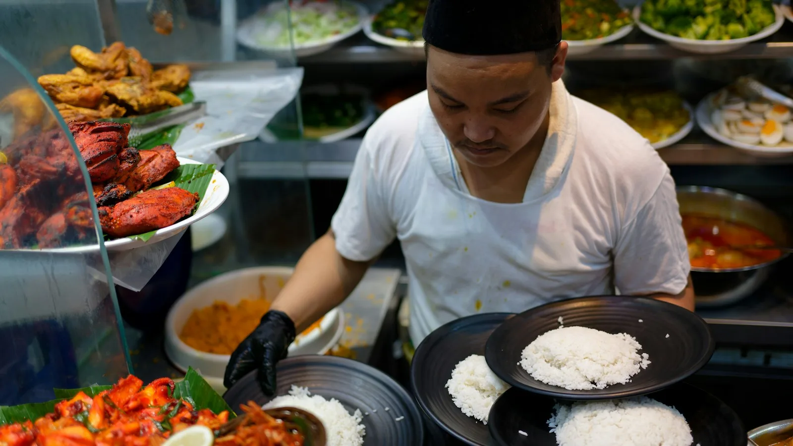 Addition posée sur la table d'un restaurant malaisien avec plats de nasi lemak et thé glacé